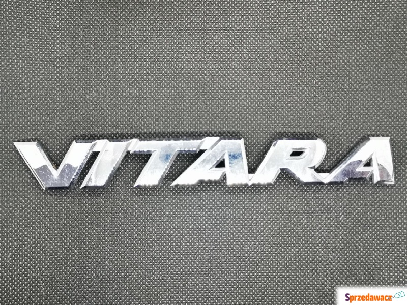 Emblemat napis Suzuki Vitara III LY 77831-54P00 - Pozostałe części - Warszawa